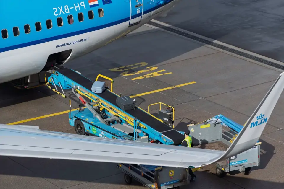 A large dog crate being loaded near an airport gate for cargo travel