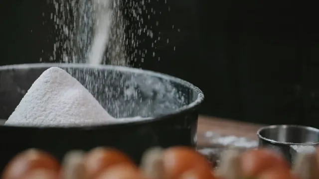 A senior dog's bowl of kibble with a light dusting of crushed supplement powder over the top