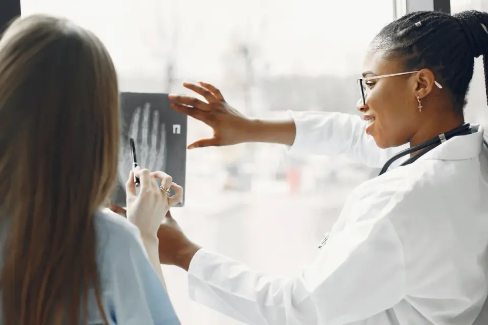 A veterinarian palpating the hip and stifle of a senior dog during an exam