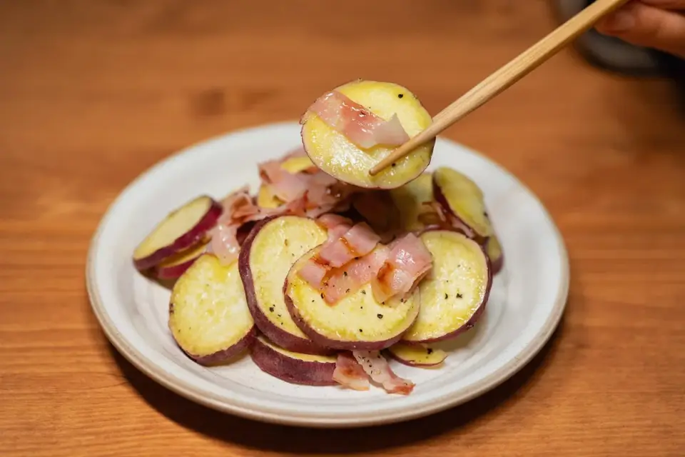 Hands cutting a cooked sweet potato into small dog-safe pieces