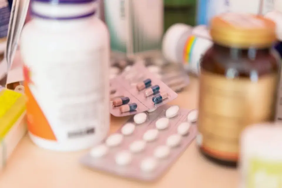 Human pill bottles next to a dog-specific supplement chew container on a counter