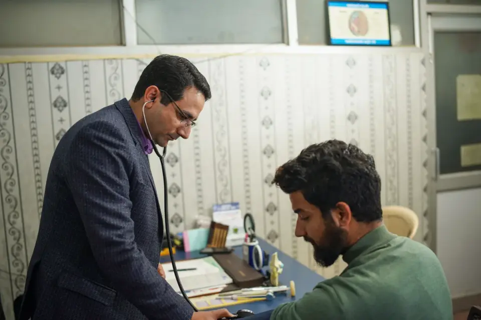 Veterinarian listening to a dog's abdomen during an exam